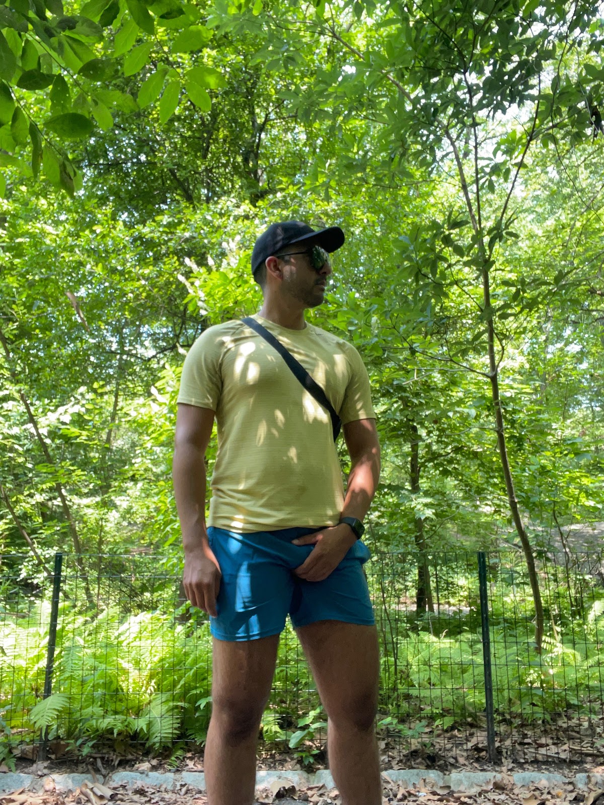 gay male posing in central park Rambles in new york city in a yellow shirt grabbibg his semi hard cock through his blue shorts while gay cruising