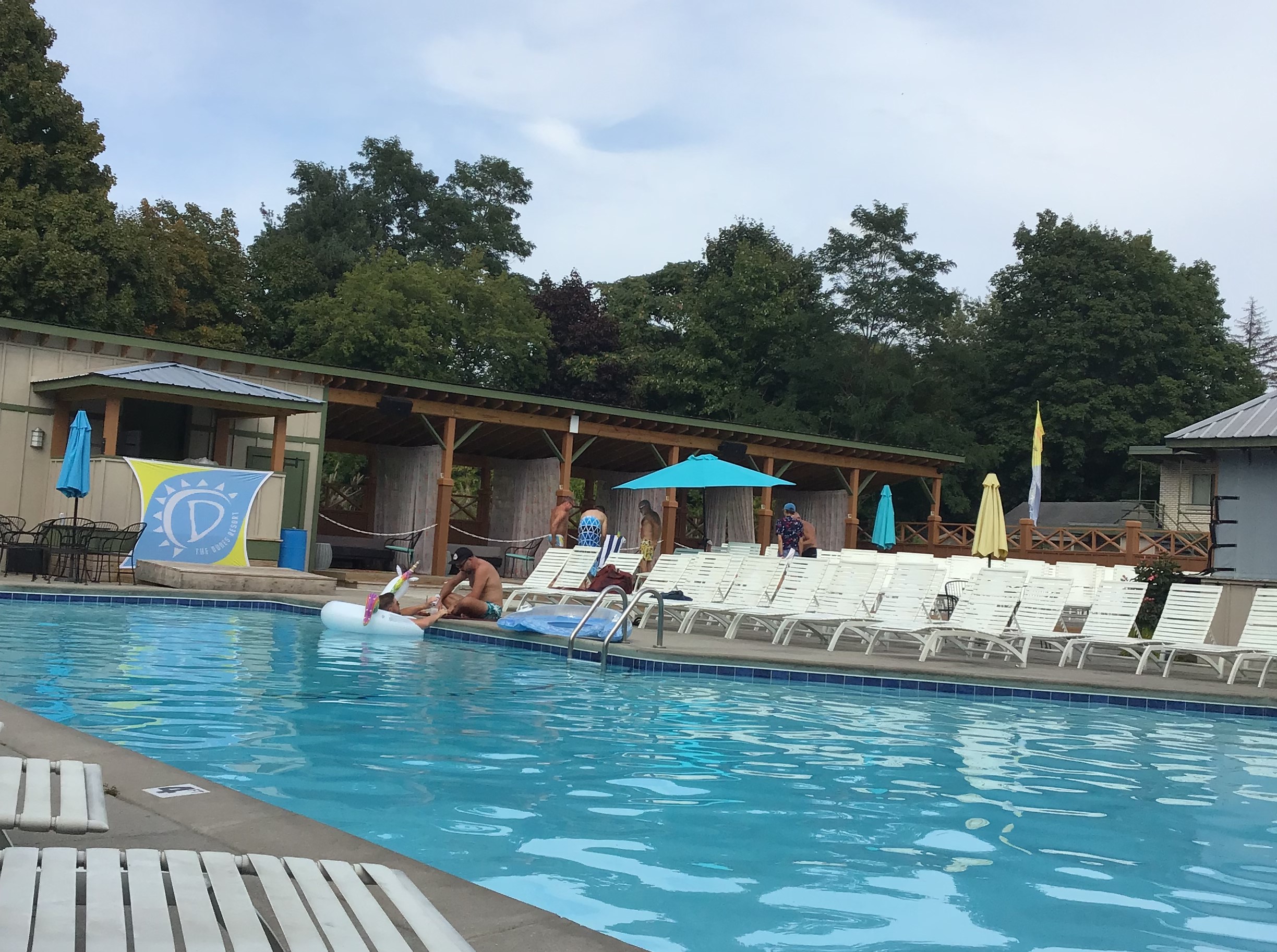 Lounging beside the swimming pool at The Dunes Gay Resort for gay vacationing males near Michigan USA