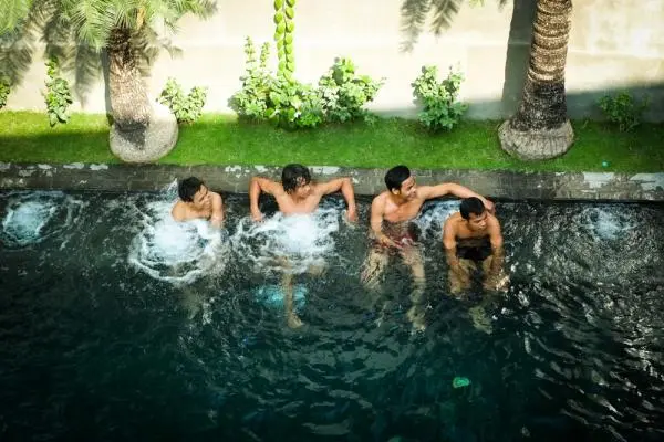 boys hanging out in poolside image of Gay Men-Only Hotel Arthur & Paul in Phnom Penh, Cambodia where gay cruising and gay bathhouse hookups happen via gay asia news