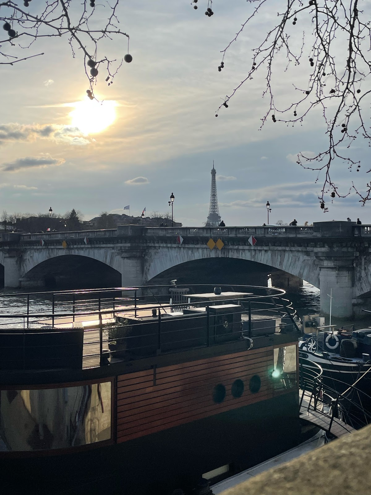 gay traveling slut takes photo of eiffel tower from harbor view showing afternoon sun and paris river water